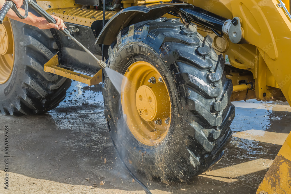 Foto Stock Washing a wheeled tractor at a car wash with a foam solution