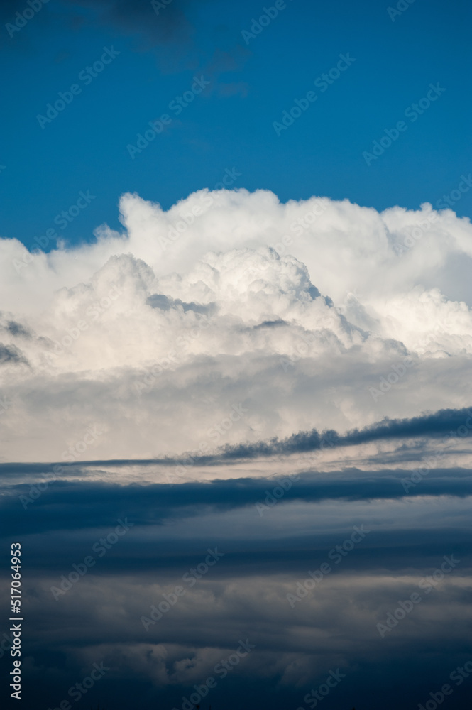 Natural background of white cumulus clouds on blue sky 