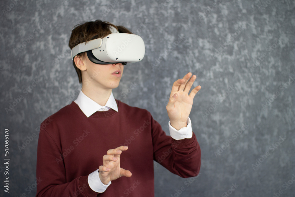 Teen male student use vr glasses and looks at empty copy space .Virtual gadgets for entertainment, work, free time and study. Virtual reality metaverse technology concept. Teen male student use vr glasses and looks at empty copy space .Virtual gadgets for entertainment, work, free time and study. Virtual reality metaverse technology concept.