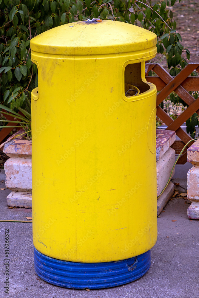Yellow trash can on rural street road Yellow trash can on rural street road