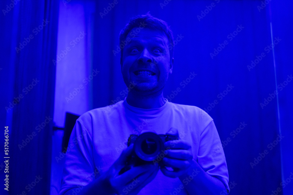 man making selfie in strange blue light. man making selfie in strange blue light.