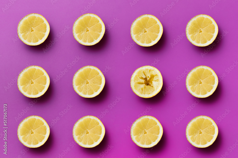 Twelve yellow sour half lemons on light purple background, one half is pressed Twelve yellow sour half lemons on light purple background, one half is pressed