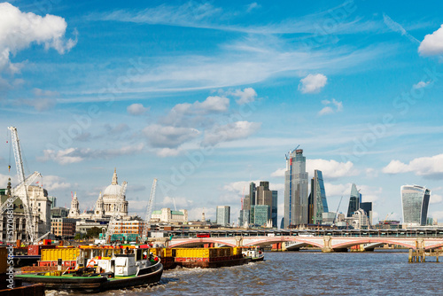 London city skyline,and tugs pulling container barges along the River Thames ,on a warm summer afternoon,London,England,UK. #517068156