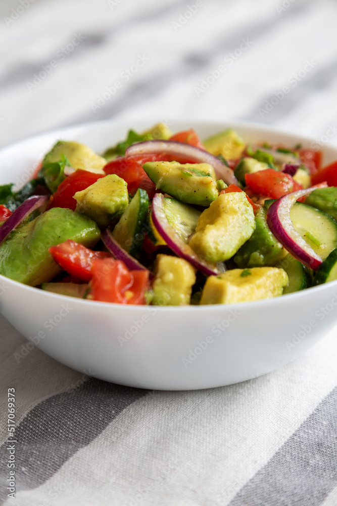Homemade Organic Cucumber, Tomato and Avocado Salad in a Bowl, side view.