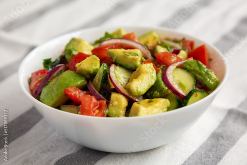 Homemade Organic Cucumber, Tomato and Avocado Salad in a Bowl, side view. Close-up.