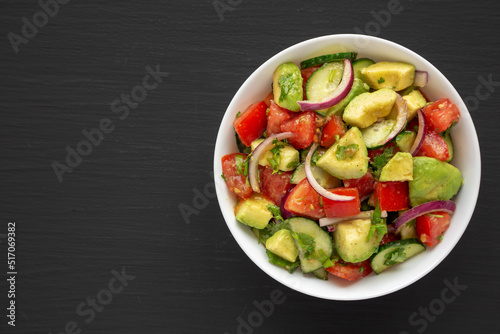 Homemade Organic Cucumber, Tomato and Avocado Salad in a Bowl, top view. Flat lay, overhead, from above. Space for text.