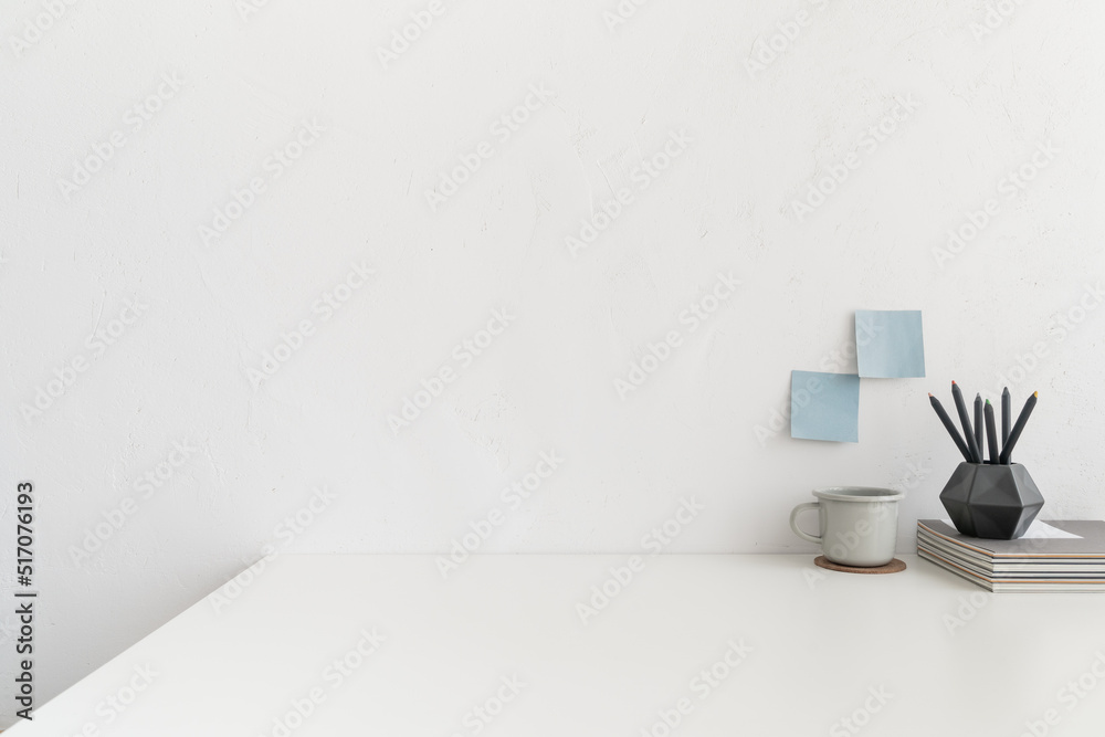 Office table, empty desk with supplies and white wall copy space. Office table, empty desk with supplies and white wall copy space.