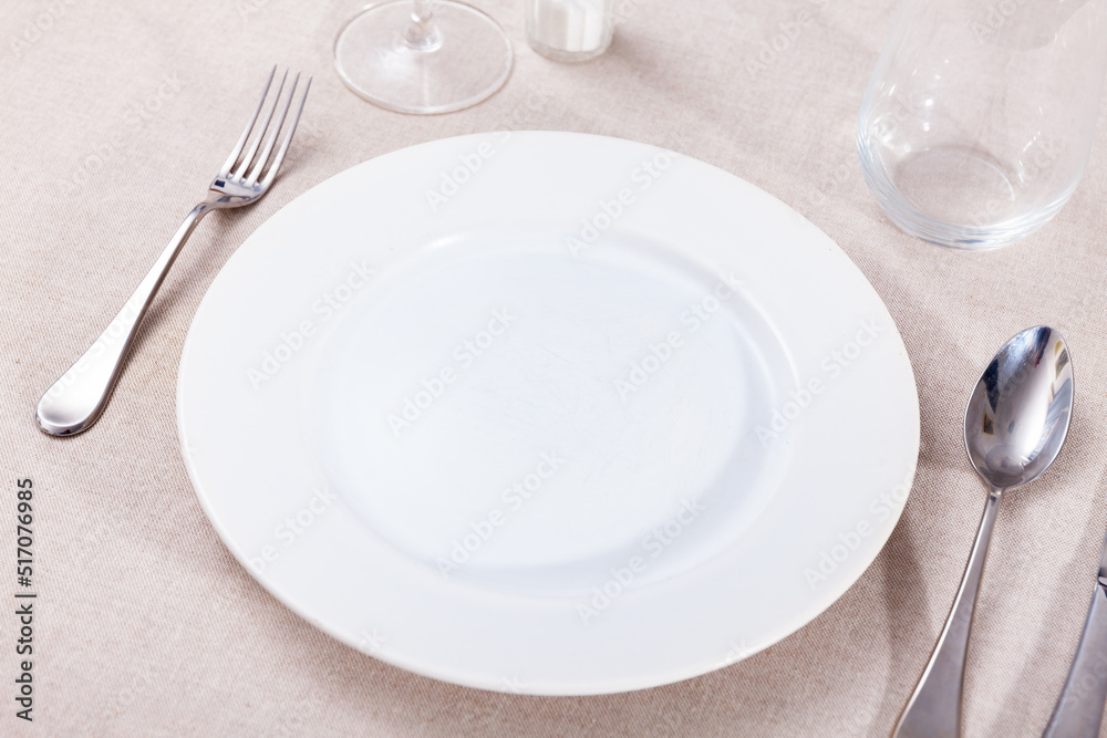Empty plate, knife and fork served on table
