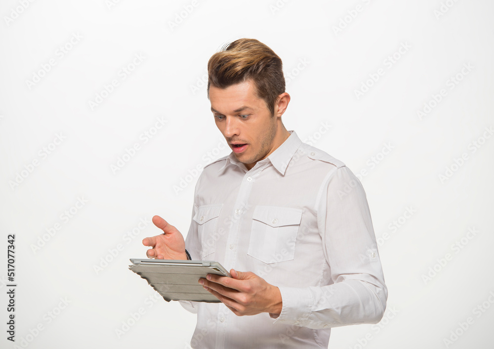 a man in a white shirt uses a tablet on a white isolated background.close-up portrait of a man with a tablet emotionally a man in a white shirt uses a tablet on a white isolated background.close-up portrait of a man with a tablet emotionally