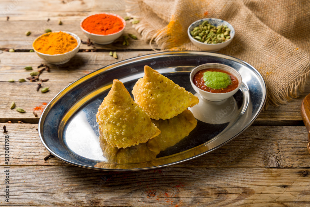 Indian samosa with vegetables and tomato mint sauce indian cuisine on old wooden table Indian samosa with vegetables and tomato mint sauce indian cuisine on old wooden table