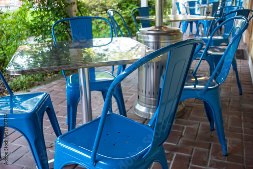 Colorful view of bright blue chairs gathered around a blue table on an outdoor patio at a restaurant