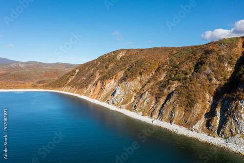 Autumn aerial photograph of the sea coast. Top view of the sea bay, coast and mountains. Sunny weather. Taui Bay, Sea of Okhotsk. Nature of the Magadan region and Siberia. Far East  of Russia. photo