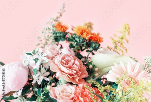 Bouquet of gerbera, roses and carnations on pink background.