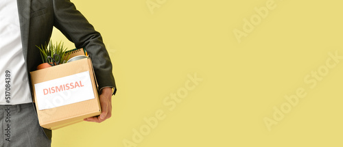 Fired worker with personal things on yellow background with space for text