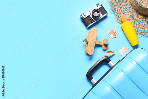 Traveler accessories and suitcase on blue background