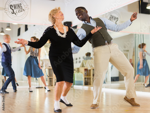 Lady learning to dance lindy hop with man in dance school photo