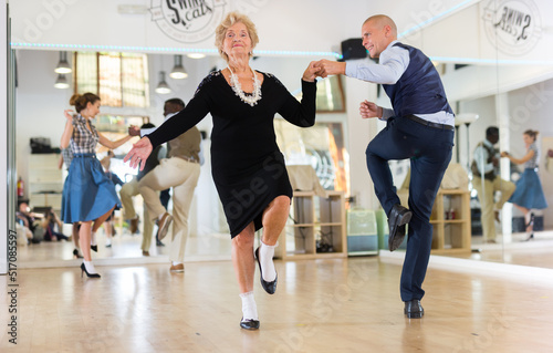Mature woman dancing swing with young man photo