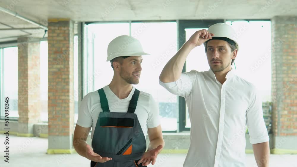 Two architects are walking along the building in progress Two architects are walking along the building in progress