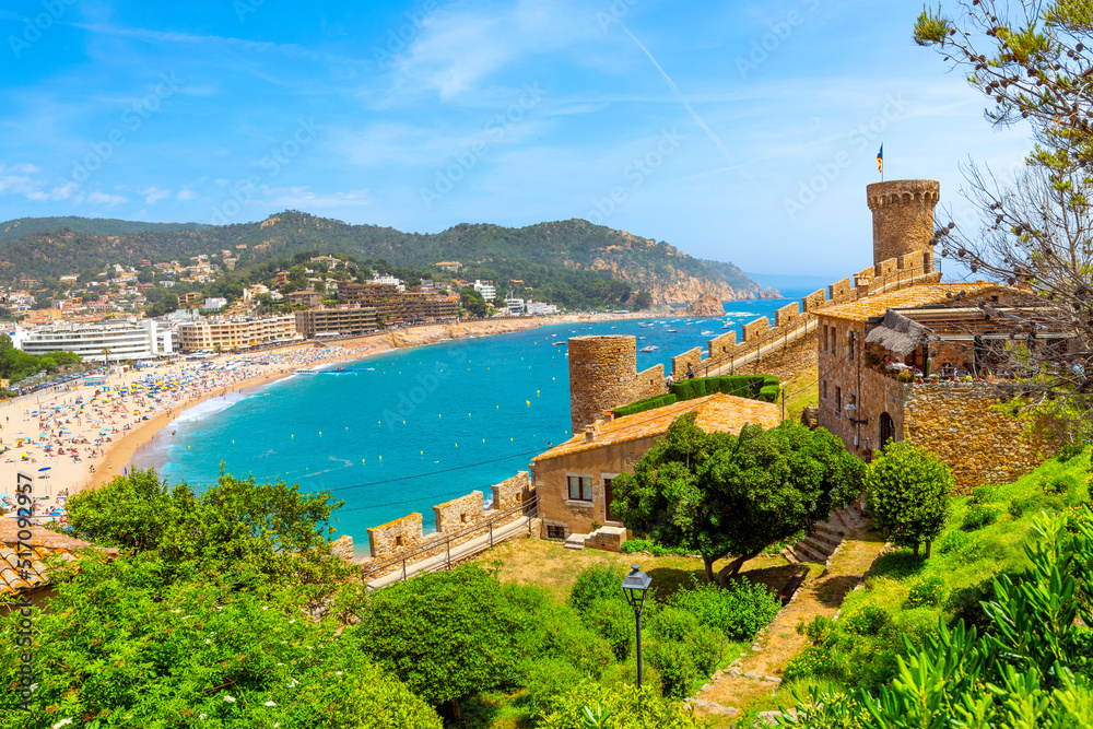 Hilltop castle view of the 12th Century castle and tower, wide sandy beach and historic whitewashed town of Tossa de Mar, on the Costa Brava coast of Catalunya, Spain.	