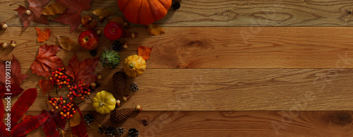 Thanksgiving Wallpaper with Fall leaves, Pumpkins and Acorns on a Natural wood Tabletop.