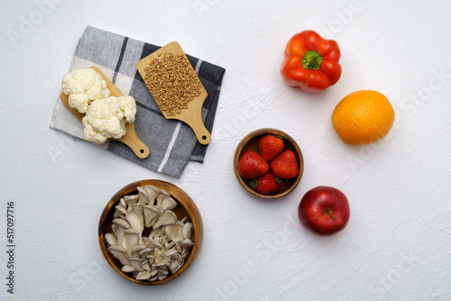 Organic food background of various fruits and vegetables, vegan food ingredients. Mushrooms, orange, strawberry, pepper