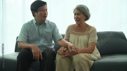 Man questioning his elderly mother's health problems in the living room at house. His mother had health problems with knee joints. Son encourages mom about health problems.