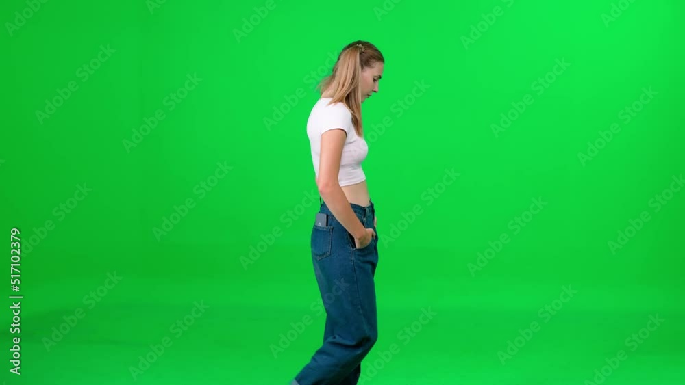 Female walking down the street on a green background, a passerby on a walk, chroma key template, a girl in a white t-shirt and blue jeans, side view. Female walking down the street on a green background, a passerby on a walk, chroma key template, a girl in a white t-shirt and blue jeans, side view.