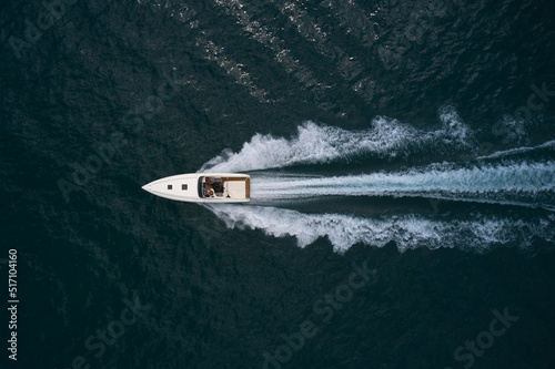 Wallpaper Mural Big white speedboat fast movement on dark water top view. Speedboat with people on the water top view. Torontodigital.ca