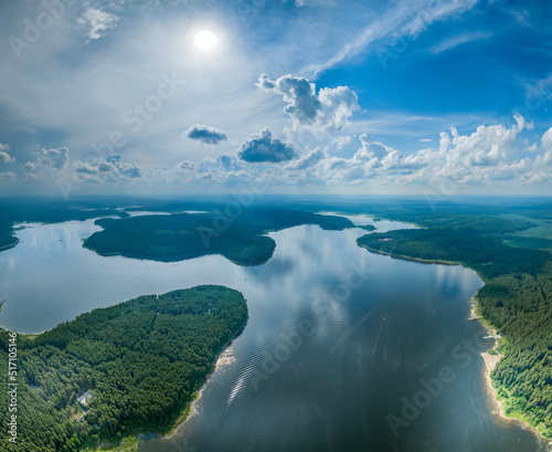 Big lake with green shores in bright sun light, aerial landscape. Recreation concept. Aerial view