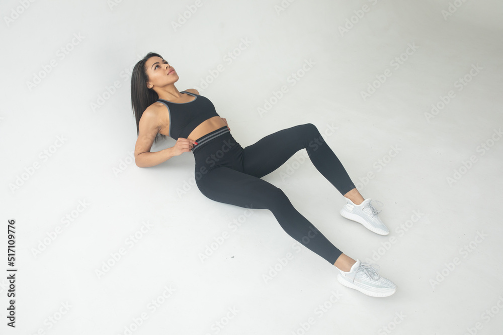 Fototapeta premium Beautiful young woman with natural make-up dressed in sports uniform, posing in the studio. Advertising sportswear and yoga wear. Healthy lifestyle, sport.