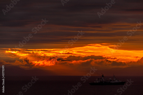 Bright dawn in the sea. Beautiful scarlet and red clouds during a colorful sunrise in Vladivostok.