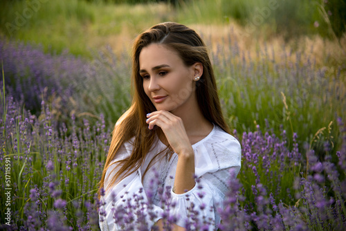 relaxing brunette beautiful girl in lavender field in white dress