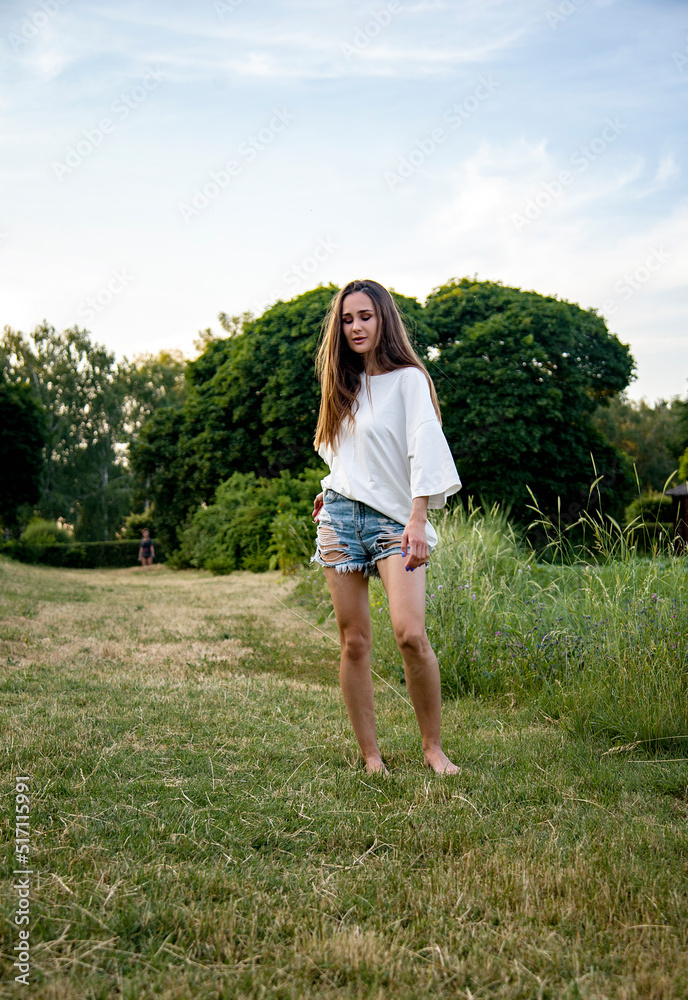 free slim brunette woman walking on the meadow opposite blue sky free slim brunette woman walking on the meadow opposite blue sky