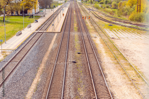 empty multiple train tracks in summer with blue sky background.