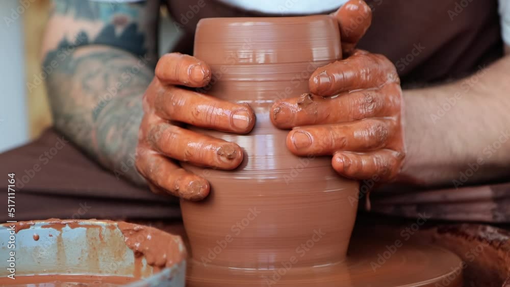 Atmospheric video of potter makes jug on potter's wheel at pottery shop, close-up hands 4k.