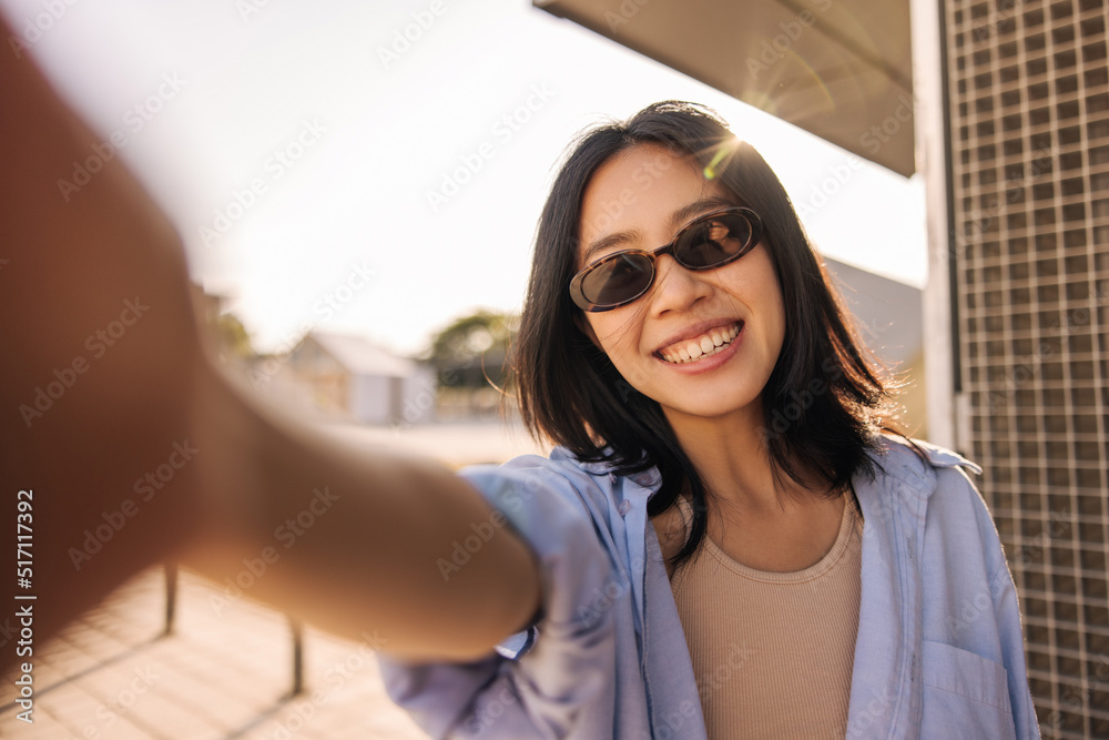 View of cheerful pretty asian woman doing selfie with camera . Dark-haired young lady in sunglasses look and smiling. Technology, lifestyle 