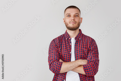 Foto smiling young guy posing with crossed arms