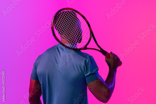 Image of back view of african american male tennis player in violet and pink neon lighting © vectorfusionart
