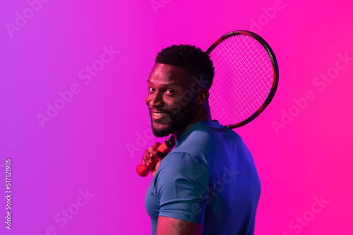Image of happy african american male tennis player in violet and pink neon lighting © vectorfusionart