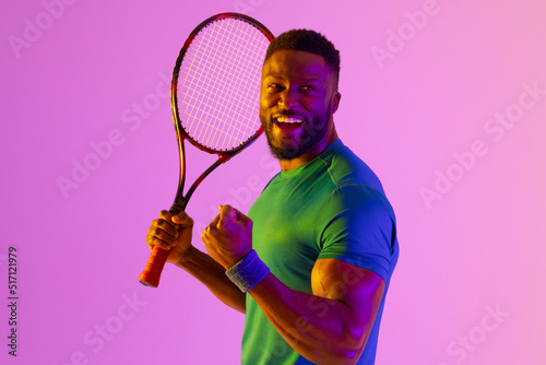 Image of successful african american male tennis player in neon violet lighting © vectorfusionart