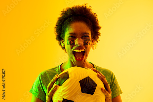 Image of african american female soccer fan with flag of brazil cheering in yellow lighting © vectorfusionart