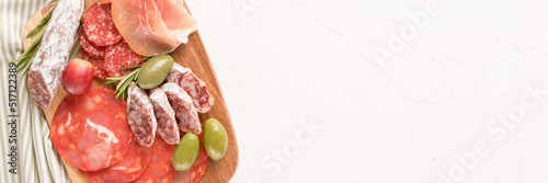 Banner with charcuterie plate with different types of sausages - salami, bresaola, proscuitto served with olives and crackers. Banner menu background with copy space. Traditional italian antipasti