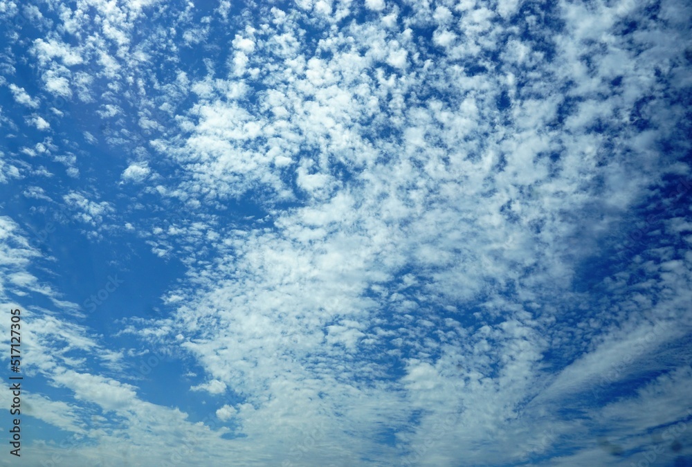 Blauer Himmel mit weißem Wolkengebilde bei Sonne am Mittag im Sommer Blauer Himmel mit weißem Wolkengebilde bei Sonne am Mittag im Sommer