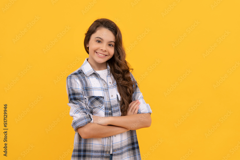 smiling teen girl in checkered shirt and with long curly hair on yellow background smiling teen girl in checkered shirt and with long curly hair on yellow background