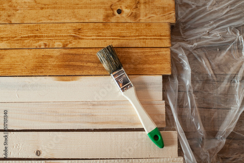 Repair concept. the brush lies on wooden slats. Half of the them is covered and the other is not. top view
