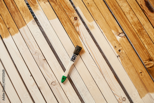 Repair concept. the brush lies on wooden slats. Half of the them is covered and the other is not.