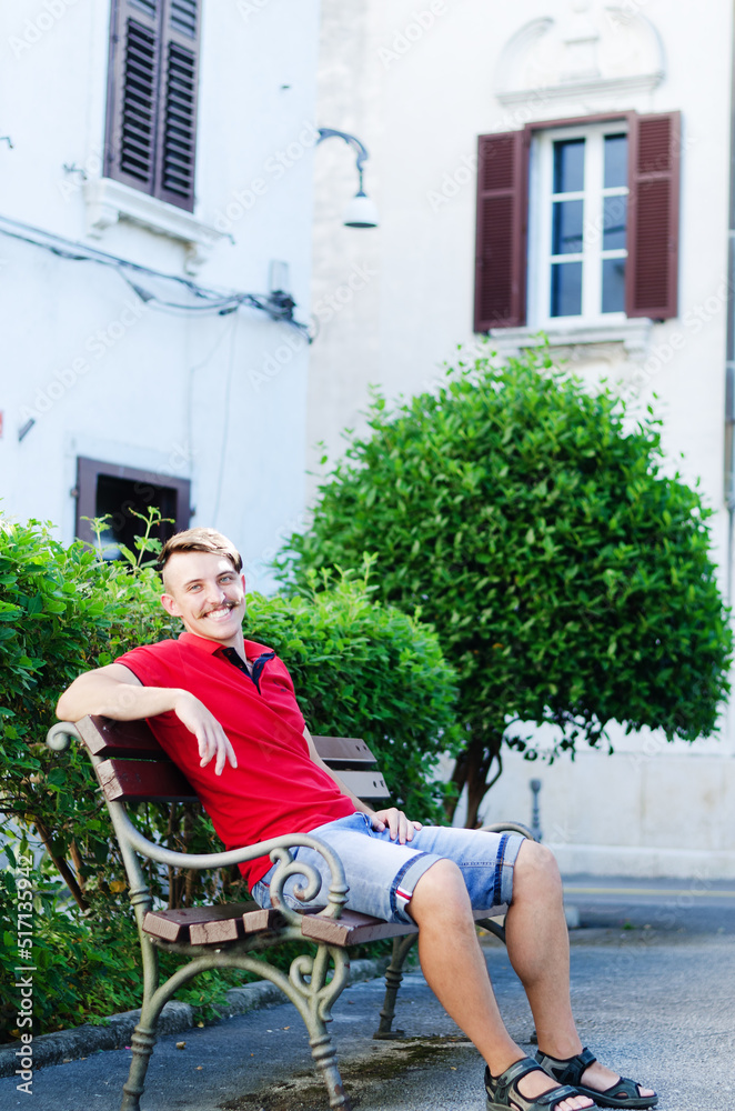 Young happy handsome bearded man, tourist walking in old city of Koper. Summer vacation. Sunglasses. Lifestyle portrait Young happy handsome bearded man, tourist walking in old city of Koper. Summer vacation. Sunglasses. Lifestyle portrait