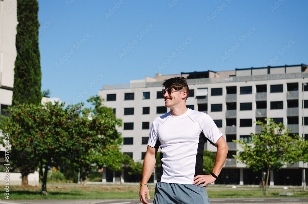 Fototapeta premium Young happy handsome bearded man, tourist relaxing in city park of Koper. Smiling. Summer vacation. Sunglasses.