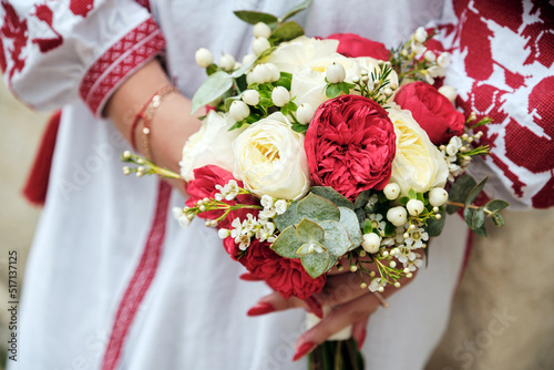 Fototapeta Naklejka Na Ścianę i Meble -  Bride in ukrainian suit holding a beautiful bouquet