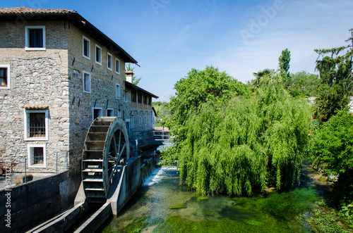 Un salice e un vecchio mulino mosso dalle acque di un canale nel piccolo borgo di Strassoldo lungo la Via Postumia, cammino che parte da Aquileia e arriva a Genova photo